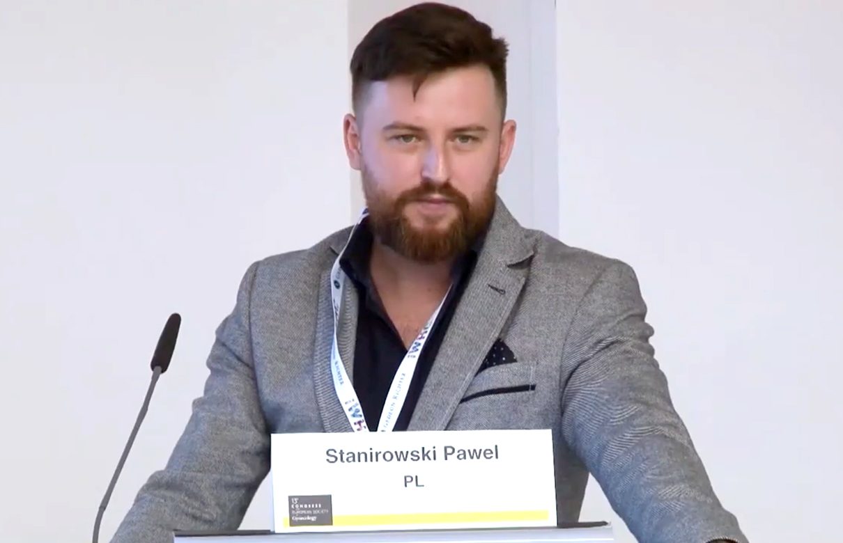 Föreläsare Pawel Stanirowski talar vid ett podium.