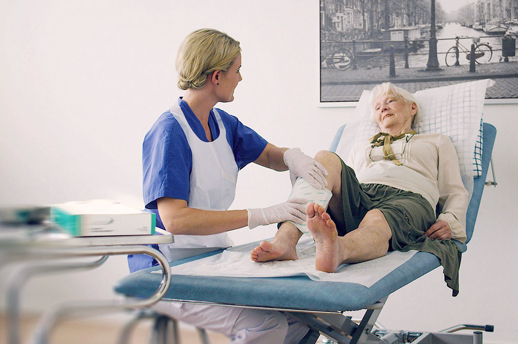 Sjuksköterska applicerar Sorbact på äldre kvinna på sjukhus